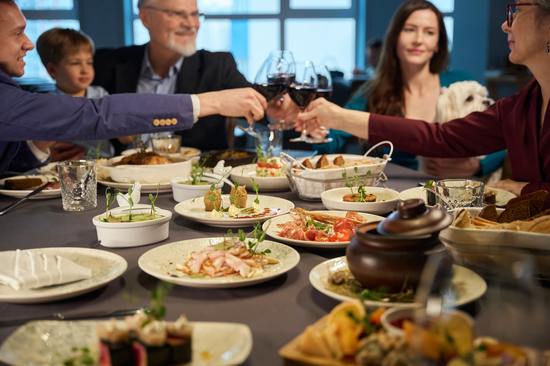 Family relishing New Years Eve dinner together in restaurant drinking red wine